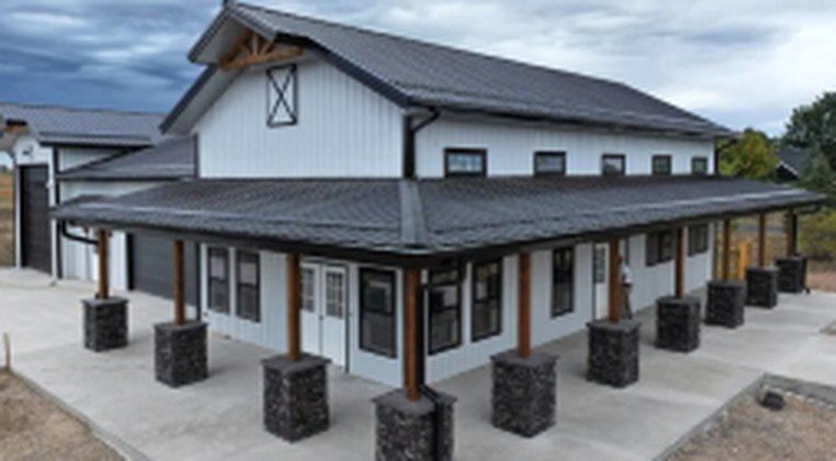 Finished single-story home with wraparound porch and stone-clad columns